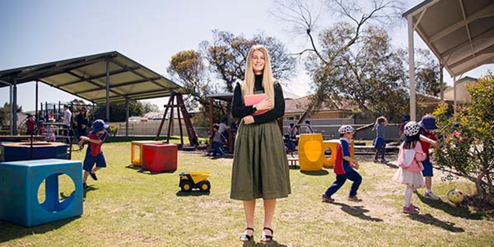 Teacher standing in primary school playground.