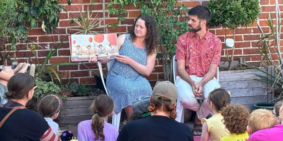 Katherine Alice and Yohann Devezy reading Don't Worry Felix to a group of children.